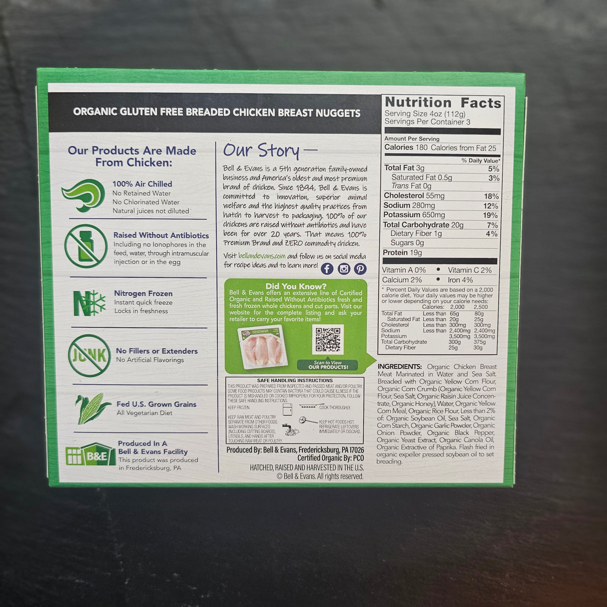Back of a food product packaging with text and icons on a dark surface