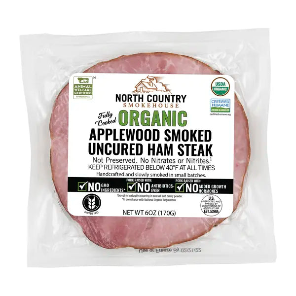 Packaged organic applewood smoked uncured ham steak with North Country Smokehouse label on a white background