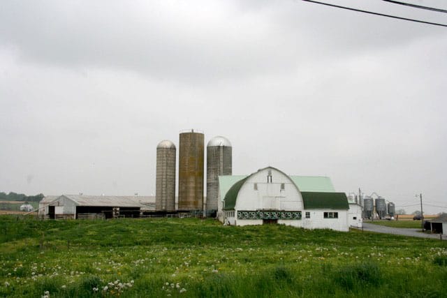 Farm with silos and a barn under a cloudy sky