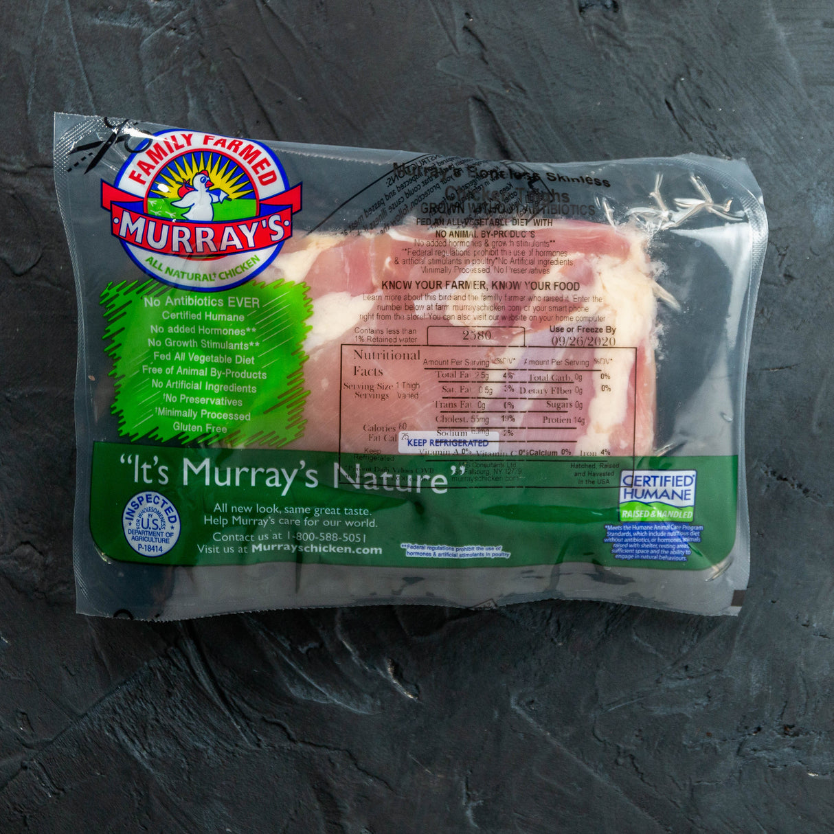 Packaged chicken thighs with Murray's branding on a dark surface