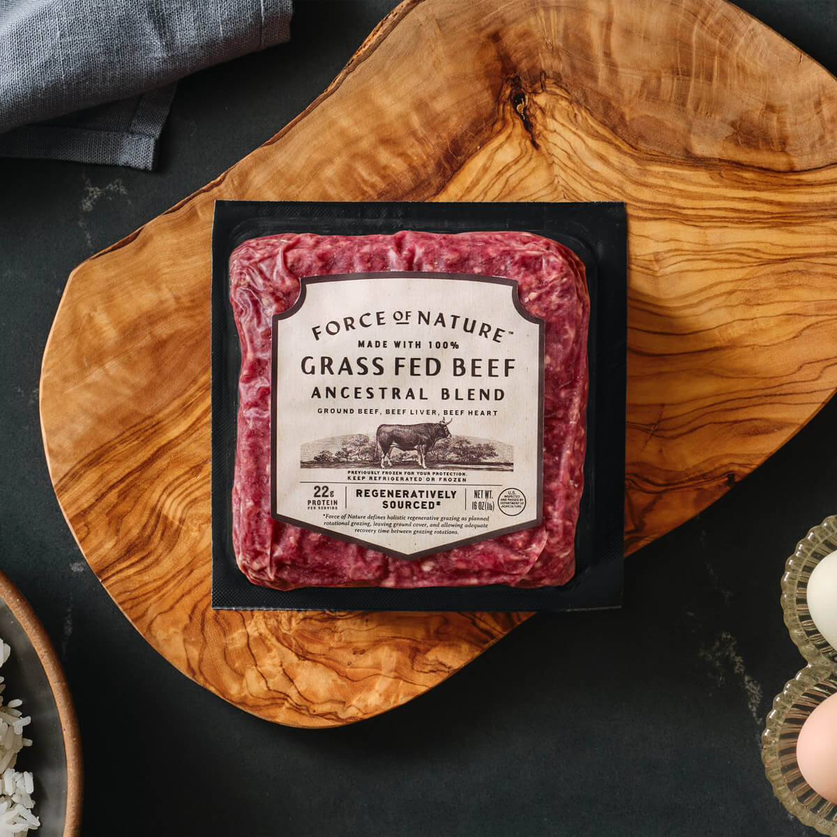 Package of Force of Nature grass fed beef on a wooden cutting board