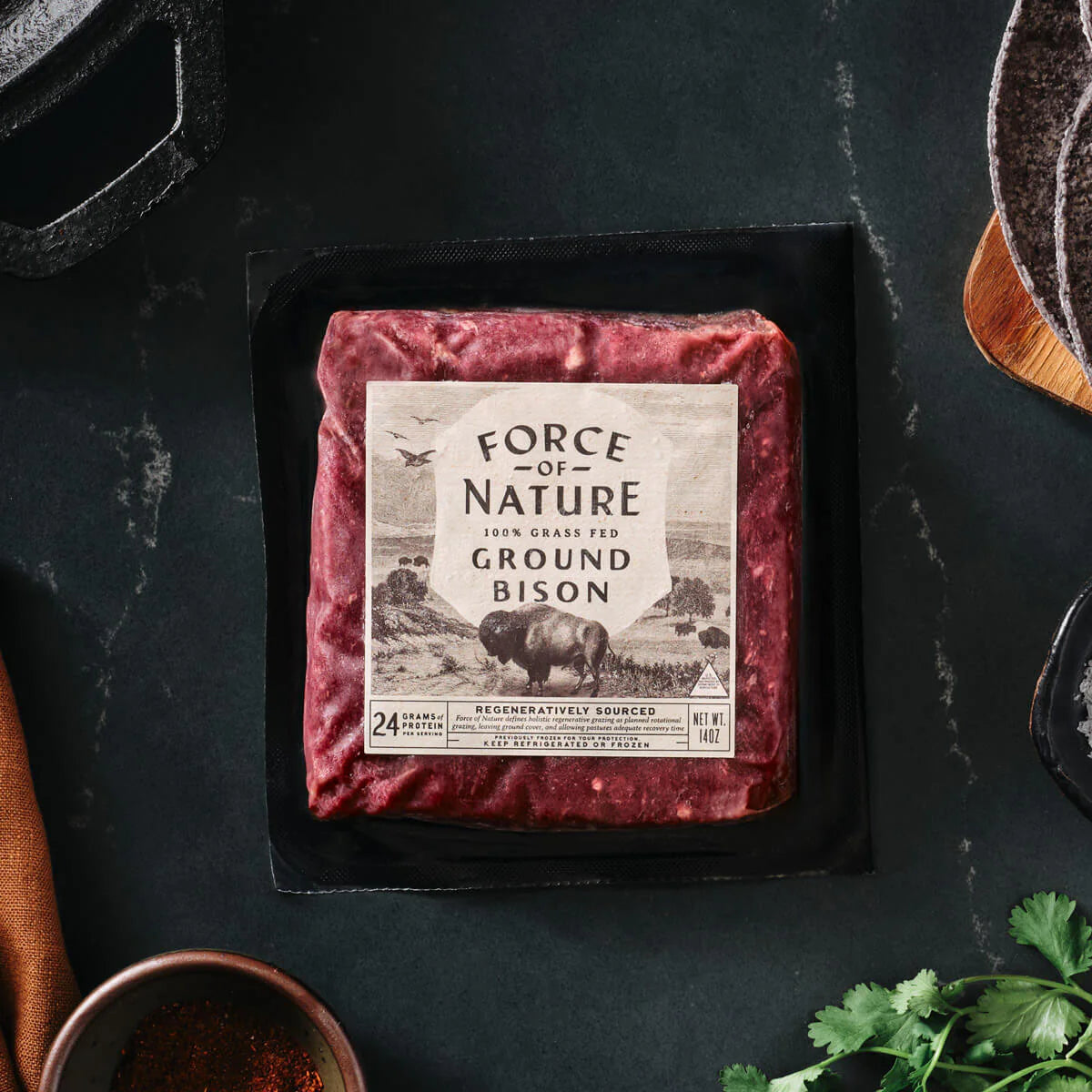 Packaged ground bison with 'Force of Nature' label on a dark surface
