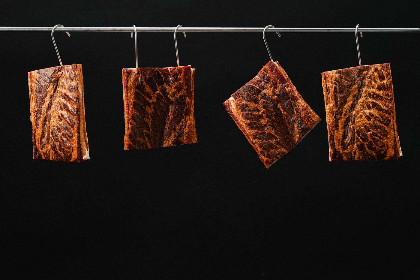Hanging pork bellys aging, from North Country Smokehouse