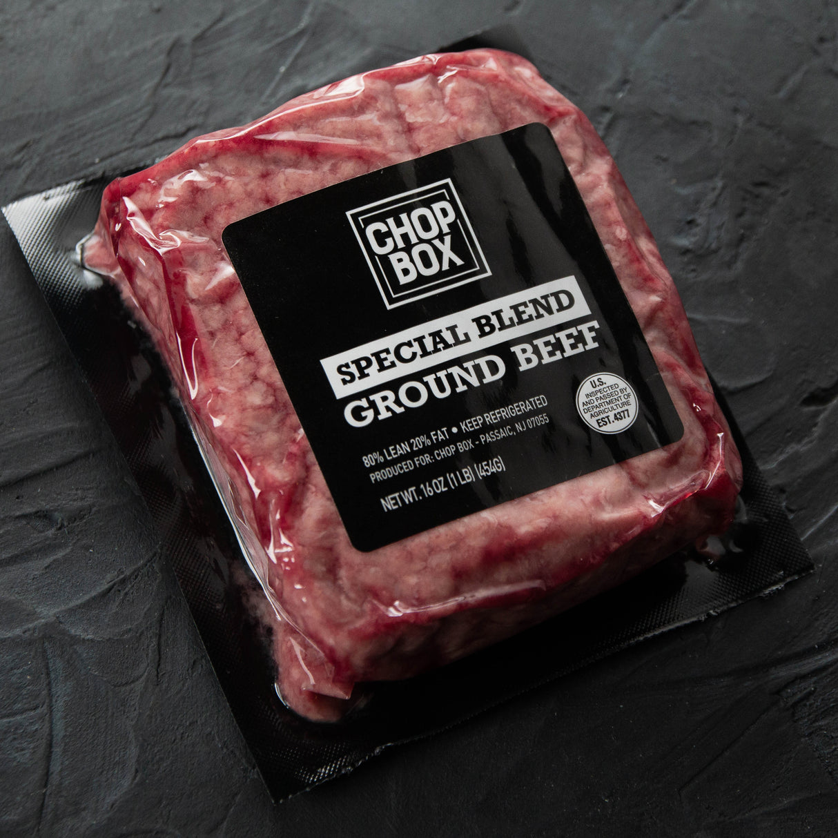 Packaged ground beef from Chop Box on a dark surface