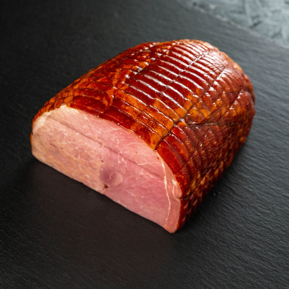 Smoked ham on a dark slate surface
