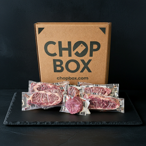 Chop Box packaging with raw meat packages on a black surface