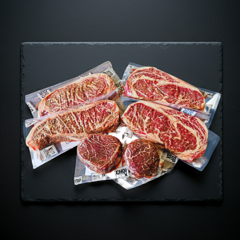 Packaged steaks on a dark slate surface