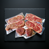 Packaged steaks on a dark slate surface